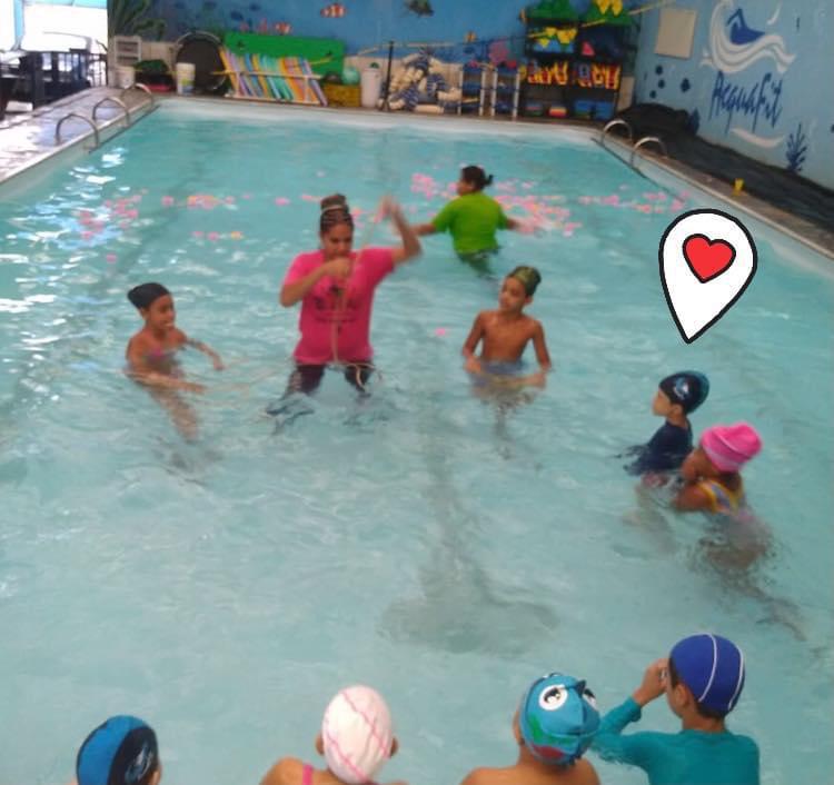 No texto autismo e a natação, a educadora física e professora de natação, Thaís Magalhães, e seus alunos durante uma aula, na piscina. 