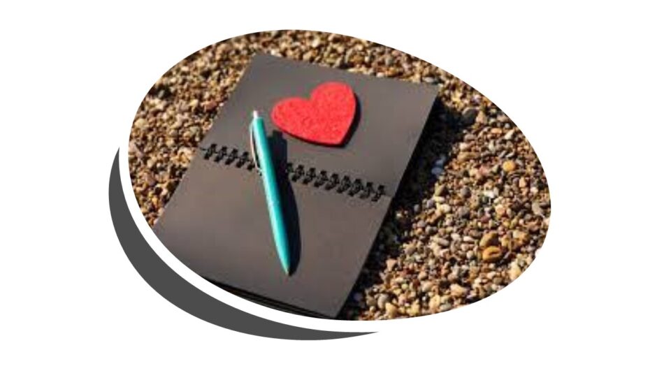 Um caderno aberto, cor cinza, sobre ele uma caneta, numa das páginas, um coração. Ilustração para o texto Devotadamente apaixonada pela palavra. Criador: https://pixy.org/ | Crédito: https://pixy.org/5759582/ Direitos autorais: CC0