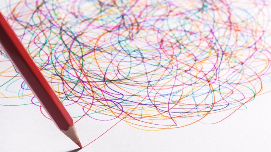 Neurodiversidade representada por um lápis de cor desenhando mais um risco num emaranhado de riscos coloridos