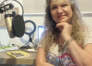 Selma Sueli lança novo programa: Mundo Autista D&I. Nesta imagem, a radialista de programas como Rádio Vivo está gravando com um microfone.